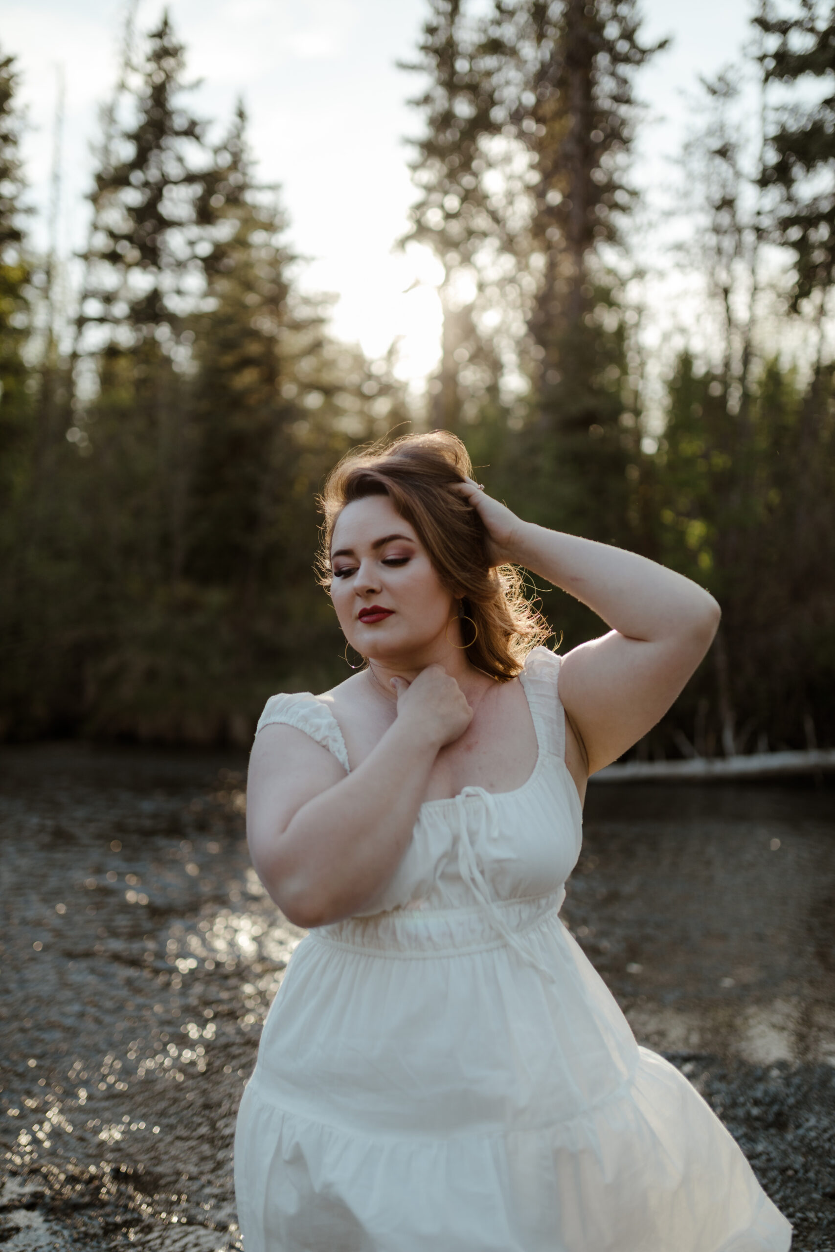 Woman in white dress posing with sun backlighting her in Eagle River, Alaska