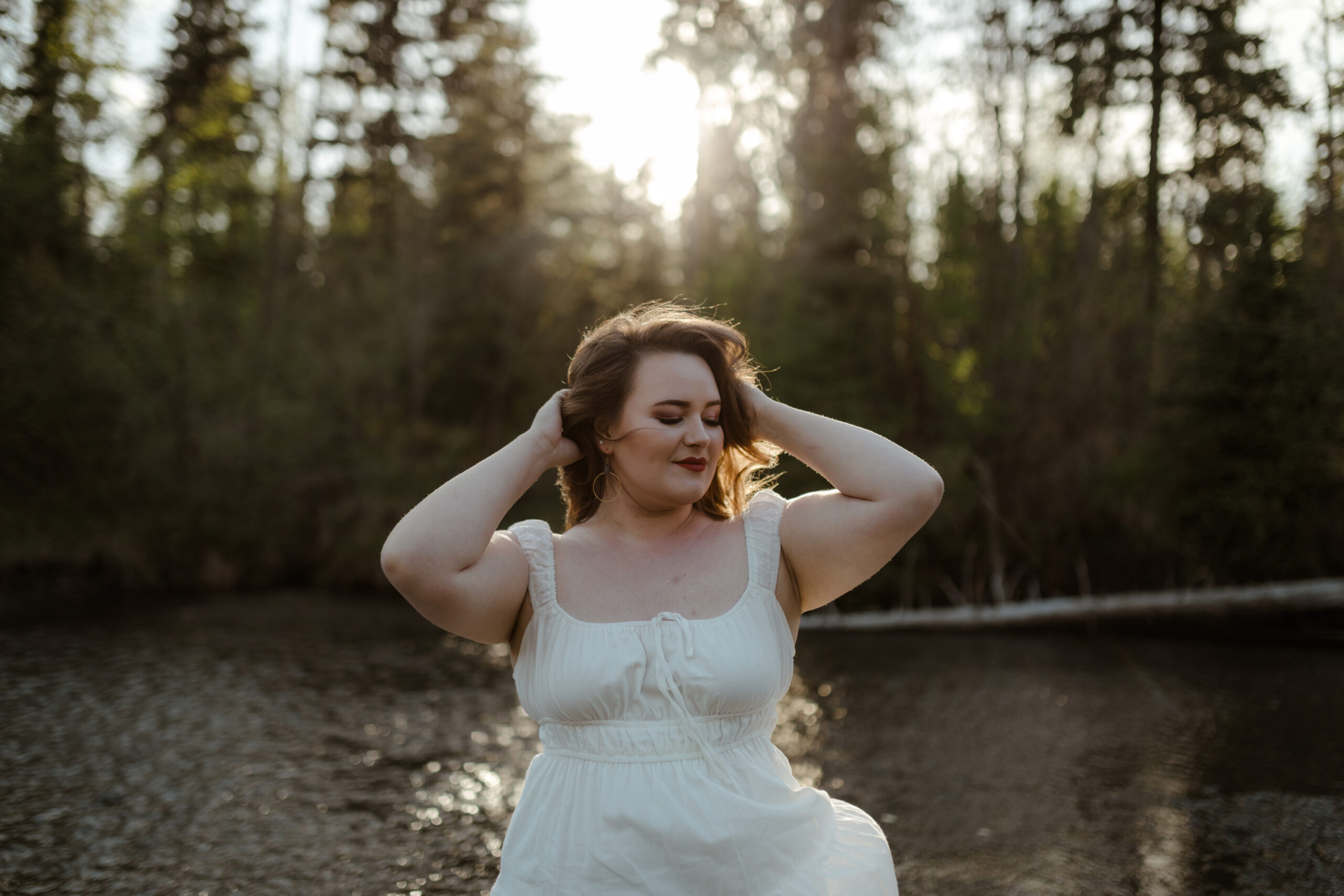 Woman in white dress posing with sun backlighting her in Eagle River, Alaska