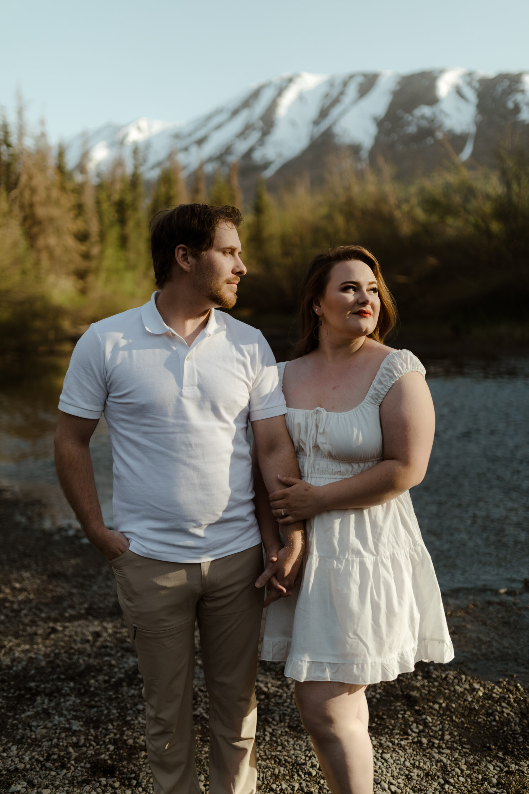 Couple embracing in front of mountain during engagement session in Eagle RIver, Alaska