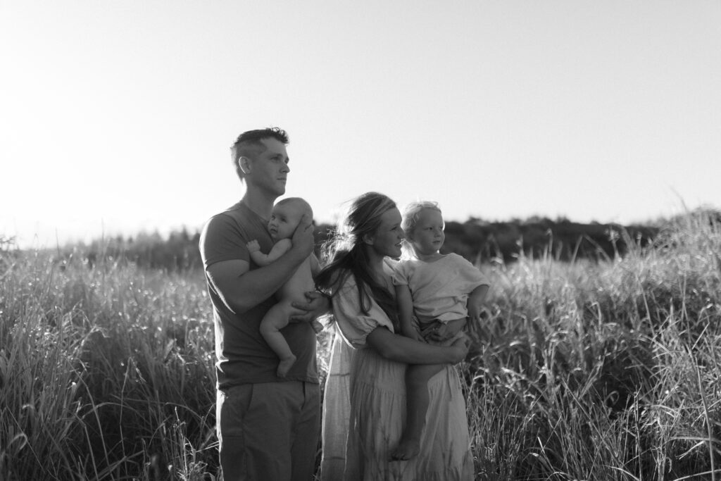 Family standing in grass at golden hour in Maui Hawaii