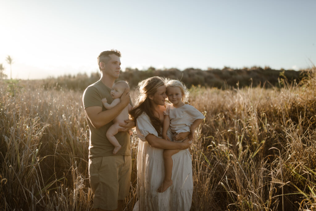 Family standing in grass at golden hour in Maui Hawaii