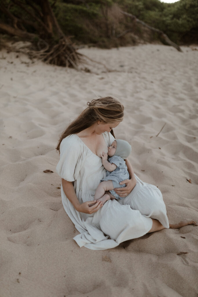 Mother breastfeeding on beach in Maui Hawaii